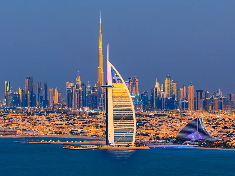 The sail-shaped Burj Al Arab hotel lit at dusk on its own island