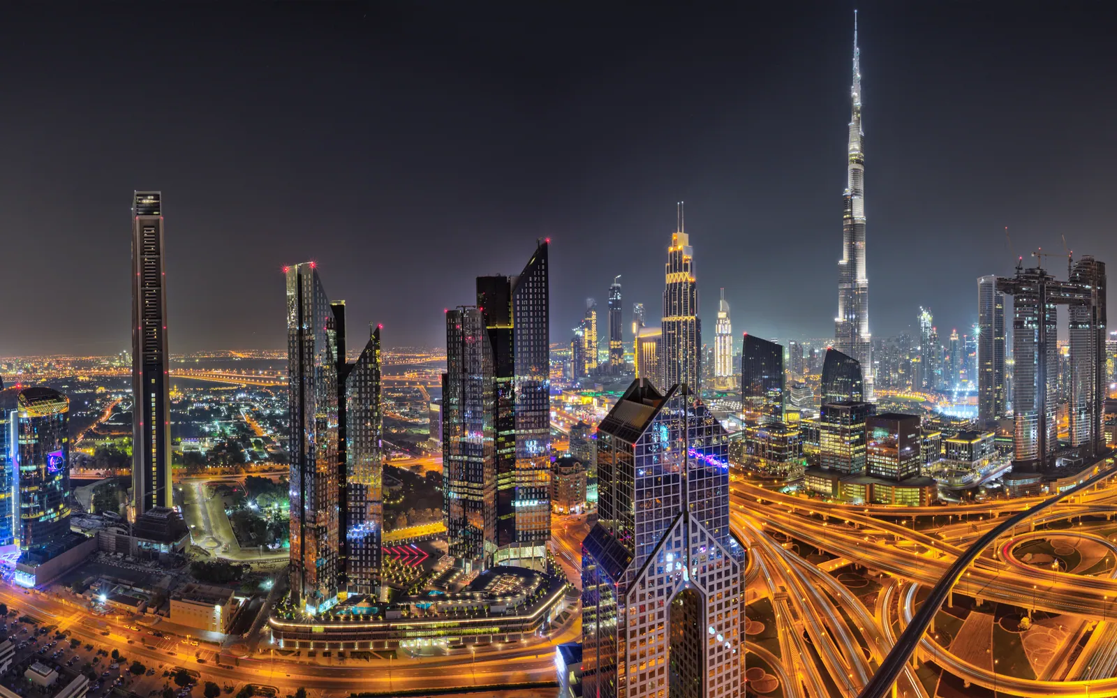 Downtown Dubai lit up at night, the Burj Khalifa above the surrounding towers