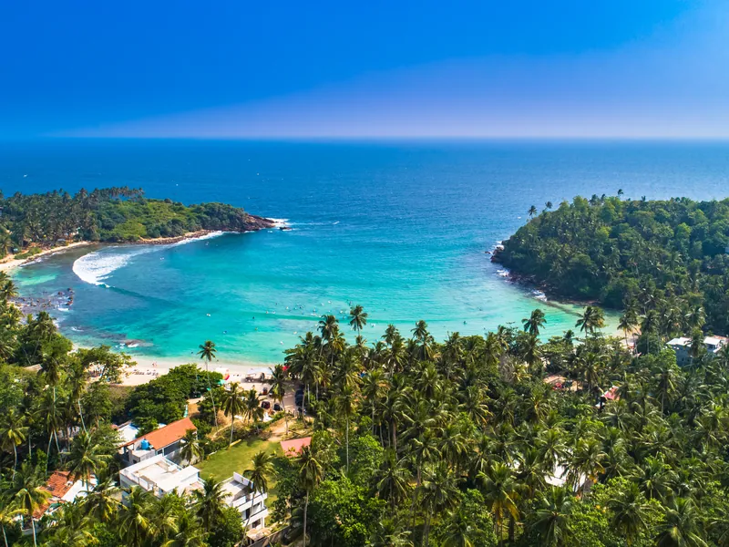 A curved bay backed by palms on the south coast